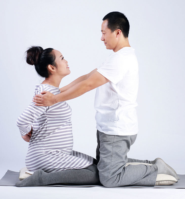 step 1:准爸爸和准妈妈骑坐在抱枕上,同时将左臂向上伸直,右臂向下